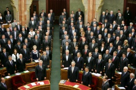 Fidesz National Assembly representatives stand for the National Anthem following adoption of the Fundamental Law. 