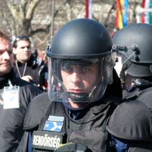 Riot cop protects Budapest Mayor Gábor Demszky from demonstrators during speech (3/15/2008).